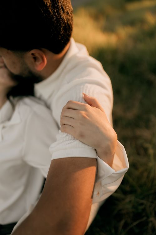 Free Intimate close-up of a couple embracing in a warm outdoor setting, conveying love and tenderness. Stock Photo