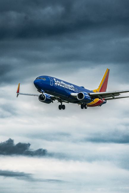 Photo by Marvin Filmaker A Southwest Airlines plane flying in a dramatic cloudy sky, showcasing dynamic weather conditions.