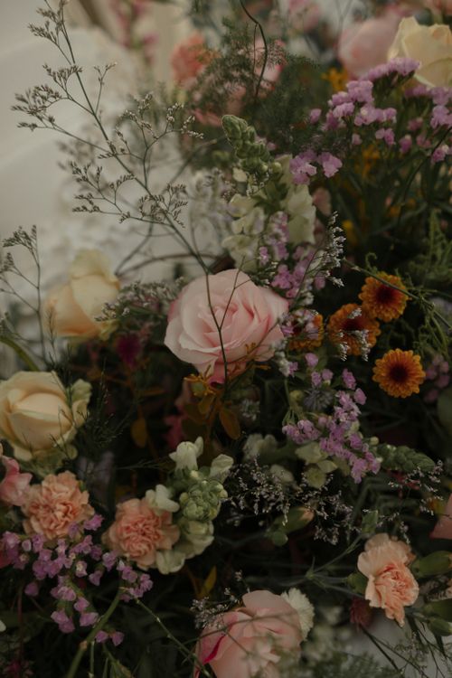 Free Beautiful bouquet with roses, carnations, and varied wildflowers in a soft, muted palette. Stock Photo