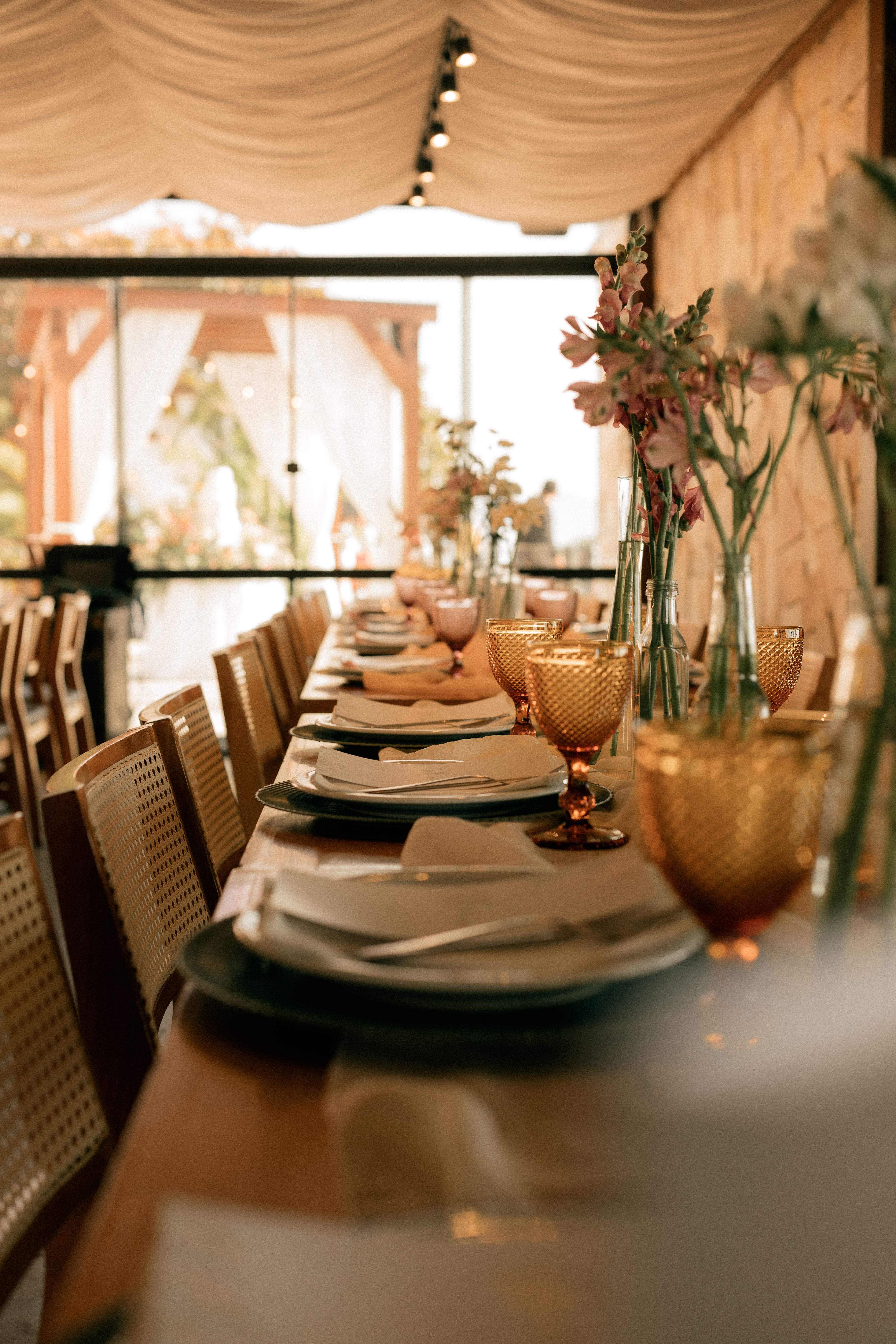 A beautifully arranged table with floral decorations for an elegant outdoor event.