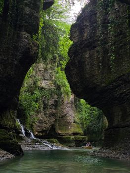 Explore a stunning gorge with lush greenery, a serene river, and cascading waterfall