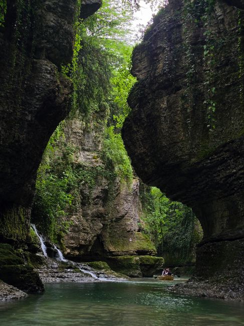 Explore a stunning gorge with lush greenery, a serene river, and cascading waterfall