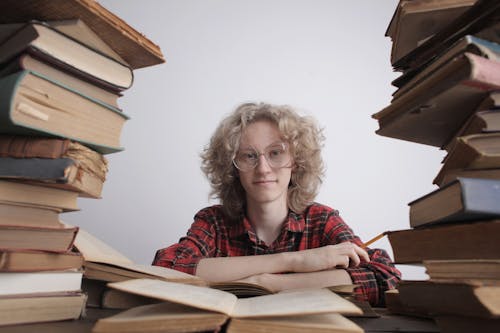 Smiling teenager with many books