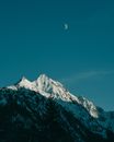 黄昏时分，白雪皑皑的山峰上空，蔚蓝的天幕中悬着一轮新月，景色令人惊叹