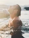 Bearded man swimming in pool water in sunlight