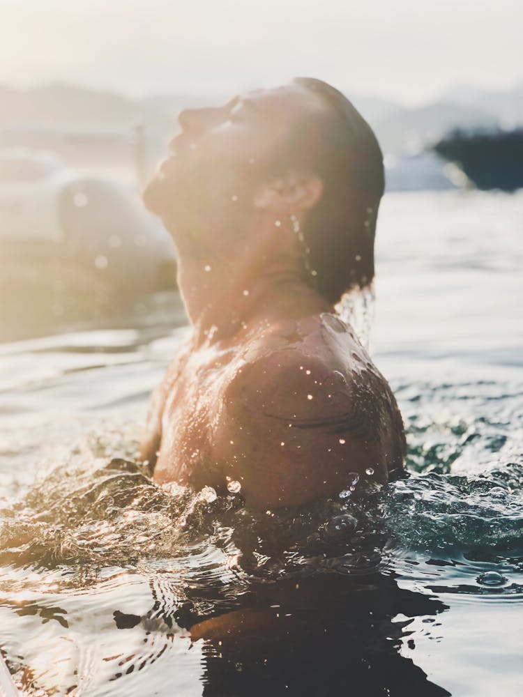 Bearded Man Swimming In Pool Water In Sunlight