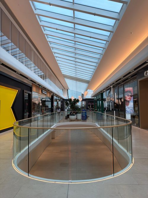 Free A bright, modern shopping mall with glass ceiling and stylish storefronts. Stock Photo