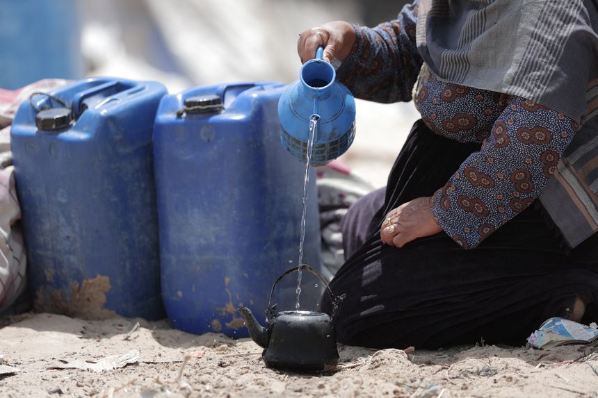 A resident pouring drinking water from a plastic container into a kettle — photo by Hosny salah on Pexels