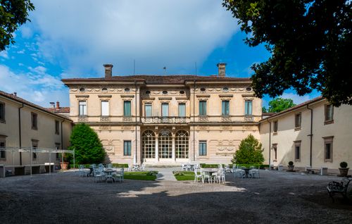 Free Stunning Italian villa courtyard with vintage architecture and elegant outdoor seating. Stock Photo