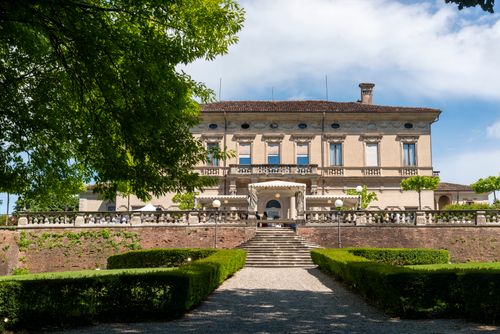Free A stunning Italian villa surrounded by lush green gardens, showcasing classic architecture and serene ambiance. Stock Photo