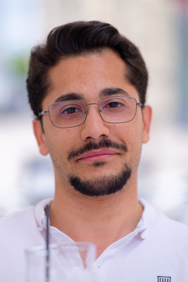 Portrait détendu d'un homme à lunettes et chemise blanche, plein d'assurance