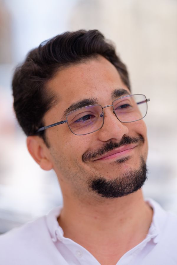 Portrait d'un homme assuré, lunettes et barbe, souriant en extérieur