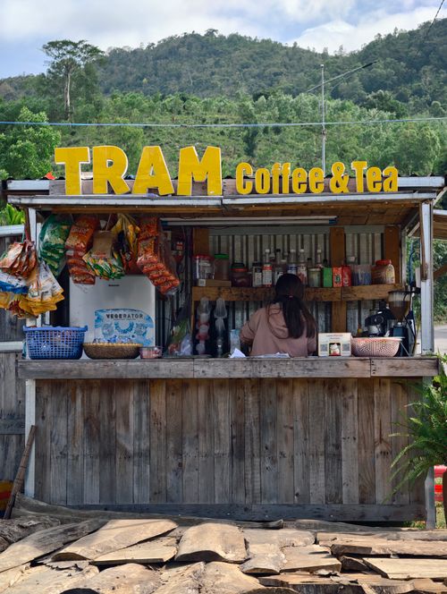 Free A rustic outdoor coffee and tea stand with snacks, featuring 'Tram' signage, set in a natural landscape. Stock Photo