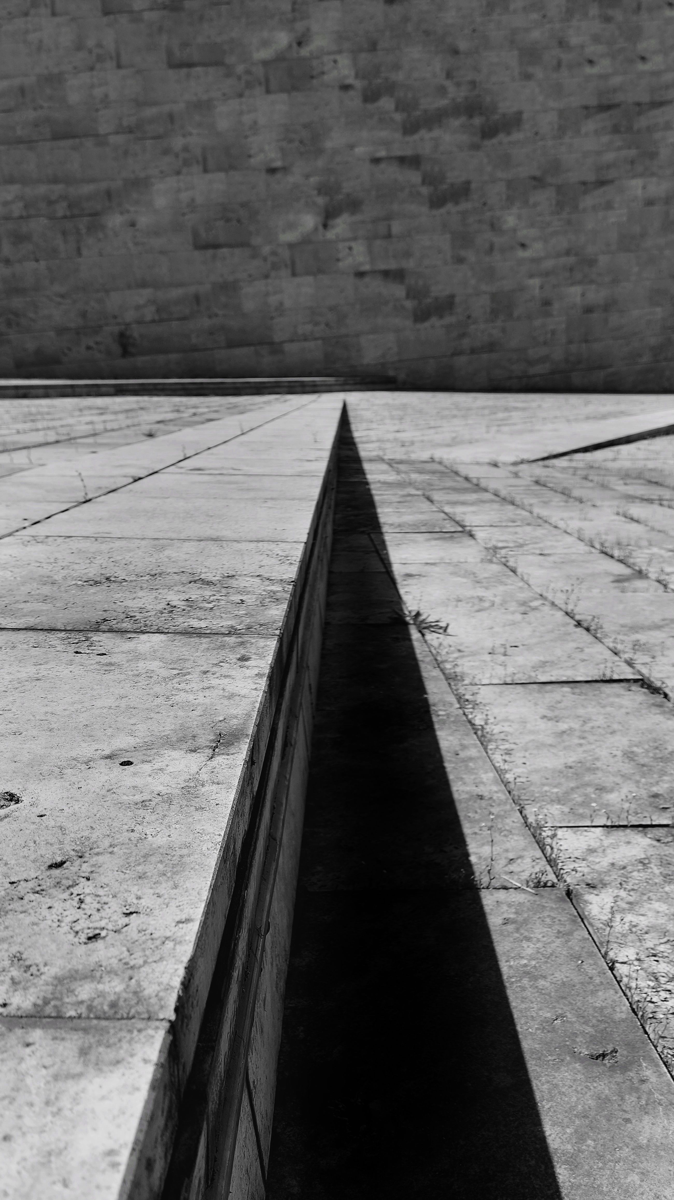 Black and white abstract image featuring urban architectural lines and shadows.