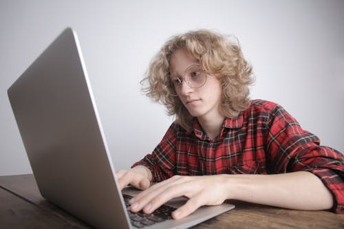 Free Woman in Red and Black CheckedShirt Using Macbook Pro Stock Photo