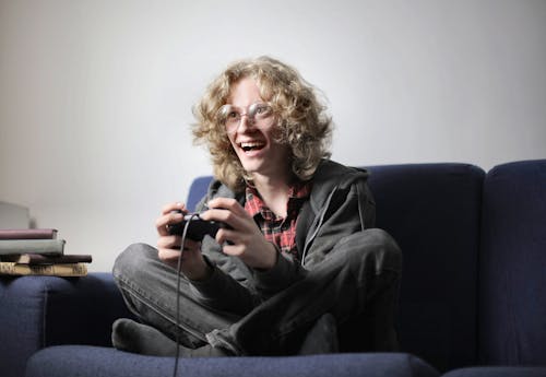 Free Joyful teenager playing video game on TV console Stock Photo