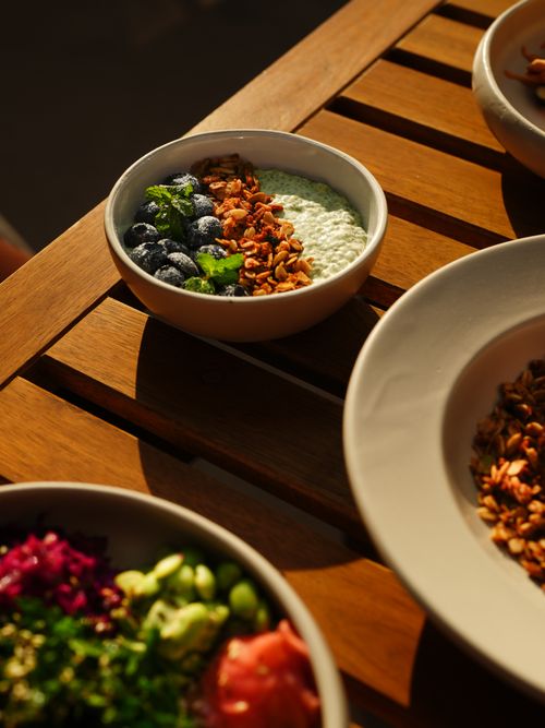 Free A vibrant yogurt bowl with blueberries, granola, and herbs on a sunlit table. Stock Photo