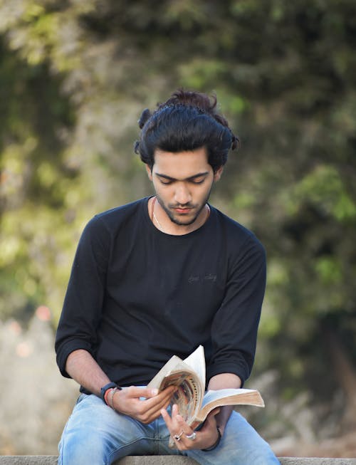 Man in Black Long Sleeve T-shirt Reading Book