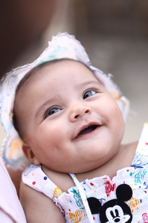 Free Adorable smiling baby in colorful attire with a cartoon character design, radiating joy. Stock Photo