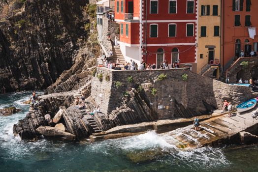 Scenic view of colorful buildings and rocky coast in Riomaggiore, Liguria, Italy.