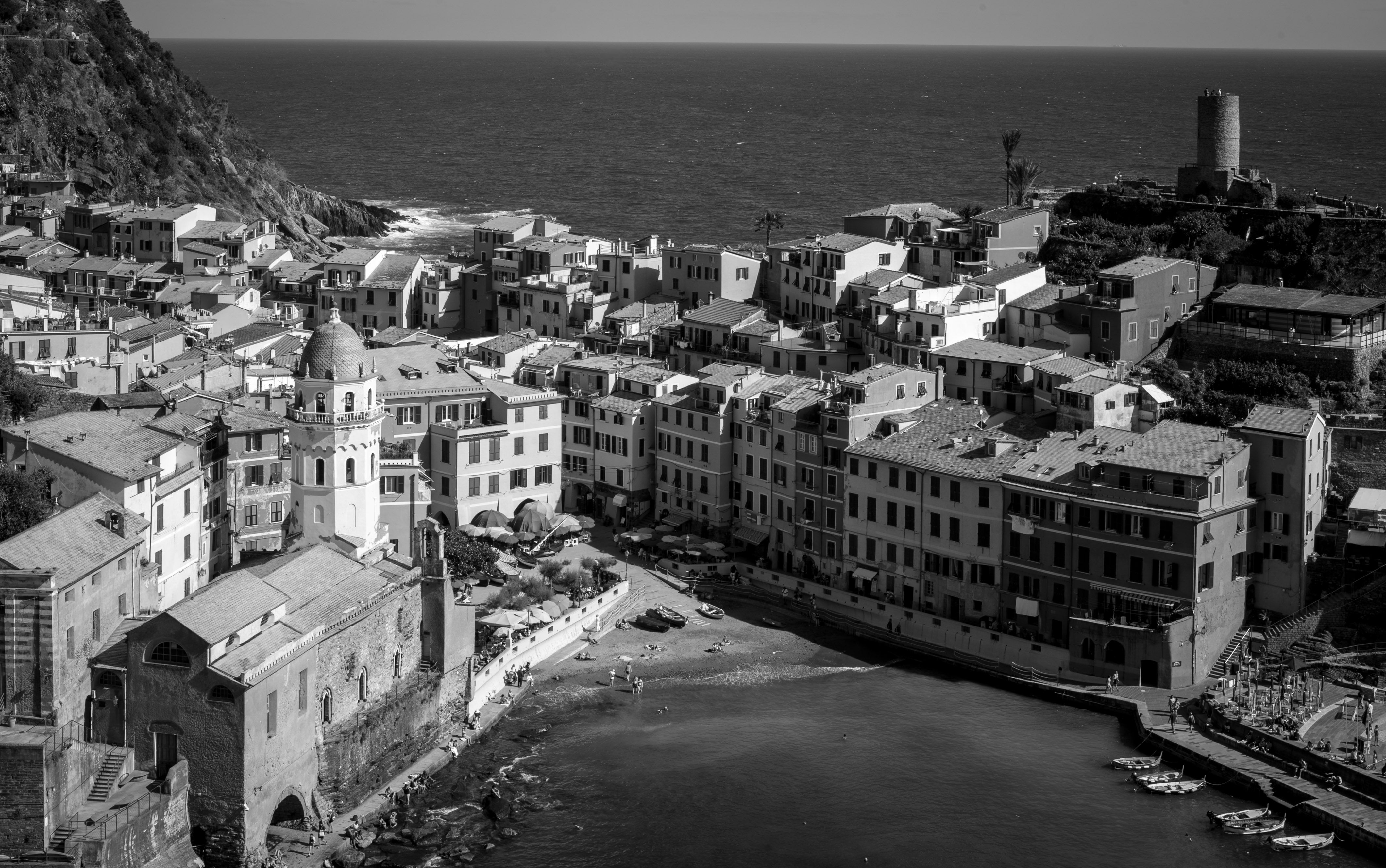 Black and white aerial shot of Vernazza, showcasing iconic Italian coastal architecture and Mediterranean sea.