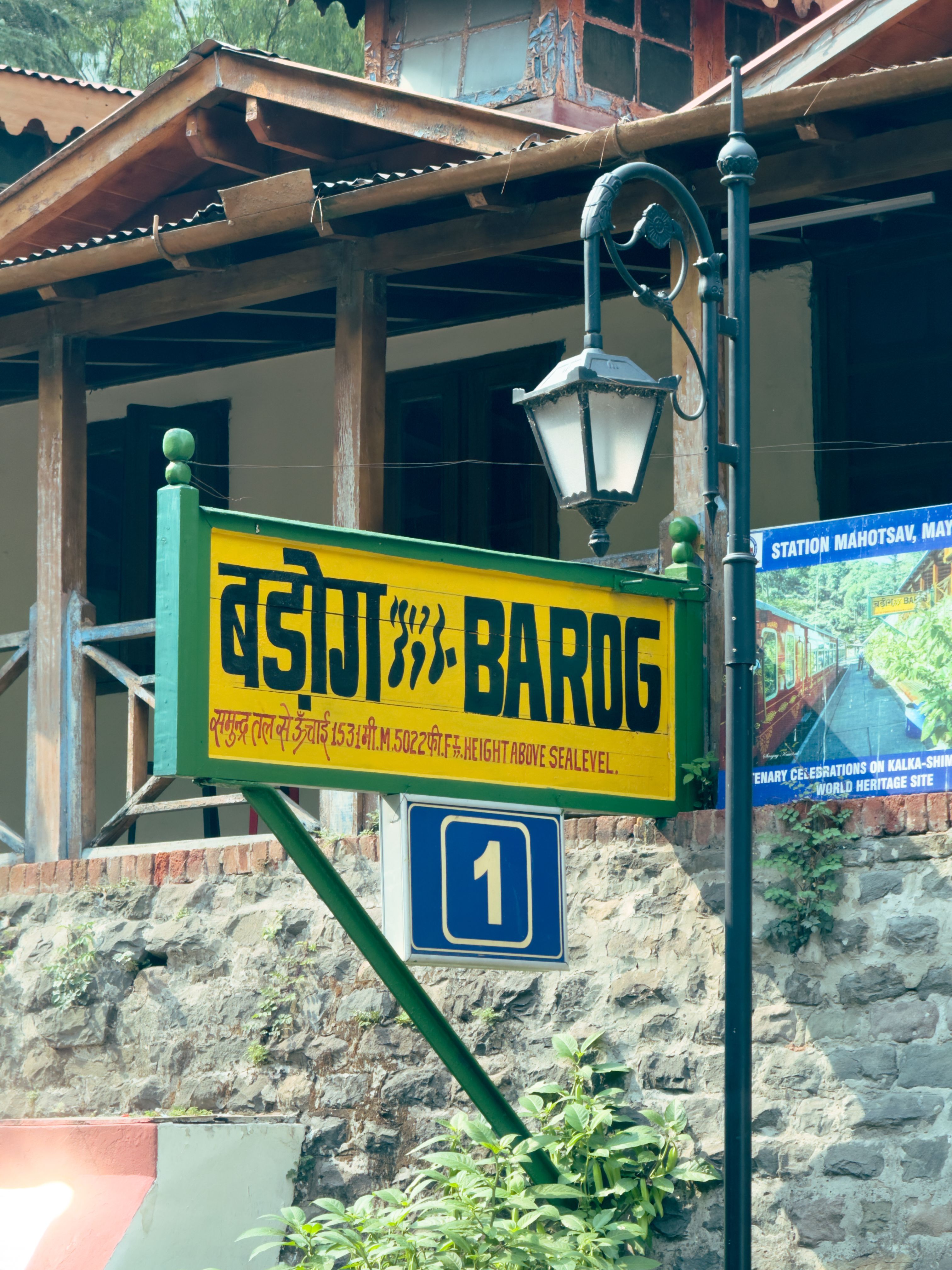 Colorful Barog station sign with elevation info in Himachal Pradesh, India.