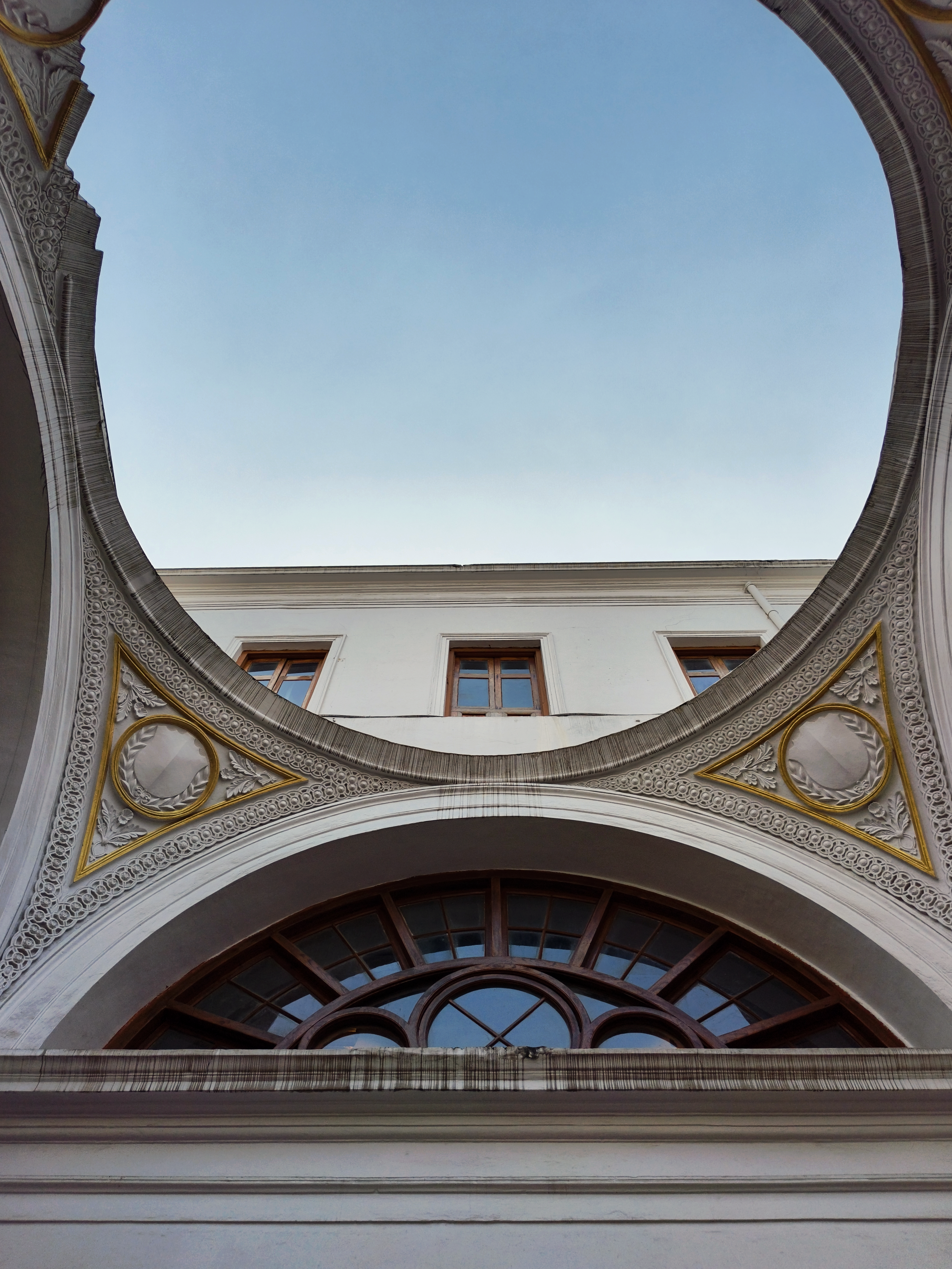 Captivating architectural design with sky view through a circular ceiling opening.