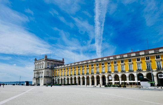 Scenic view of Praça do Comércio in Lisbon, featuring classic architecture under a vibrant blue sky.