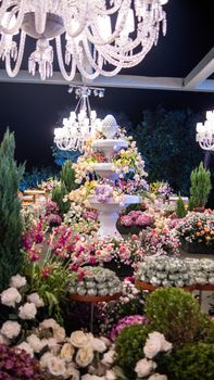 A stunning floral arrangement illuminated by chandeliers, creating a luxurious night scene.