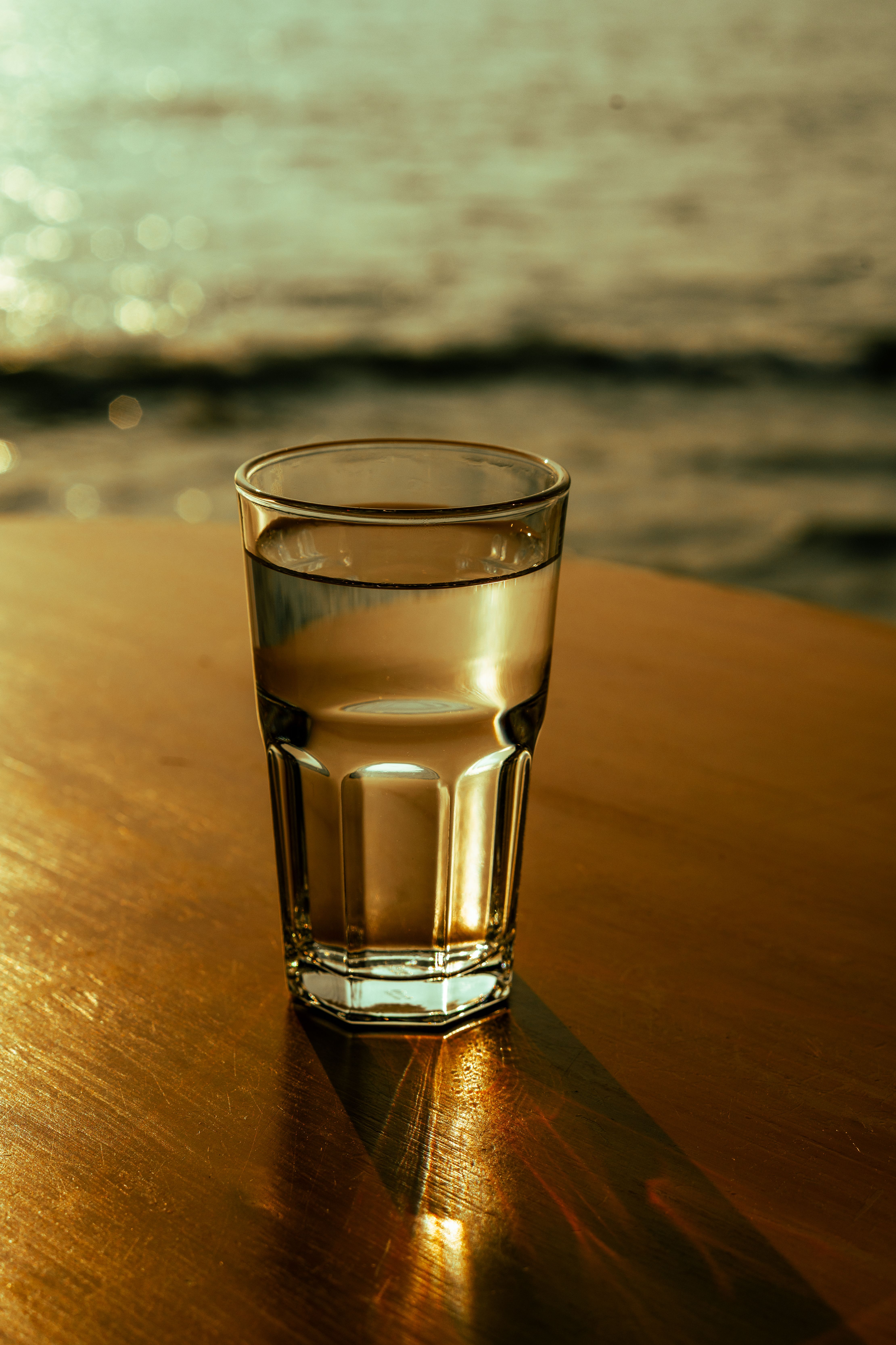 Warm glass of ajwain water on a bedside table for nighttime digestion benefits.