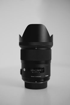 Black camera lens with focus ring and aperture settings on a clean white background.