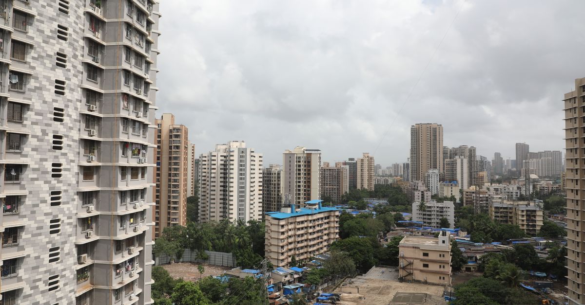 Aerial cityscape showcasing high-rise buildings and dense urban environment on a cloudy day.