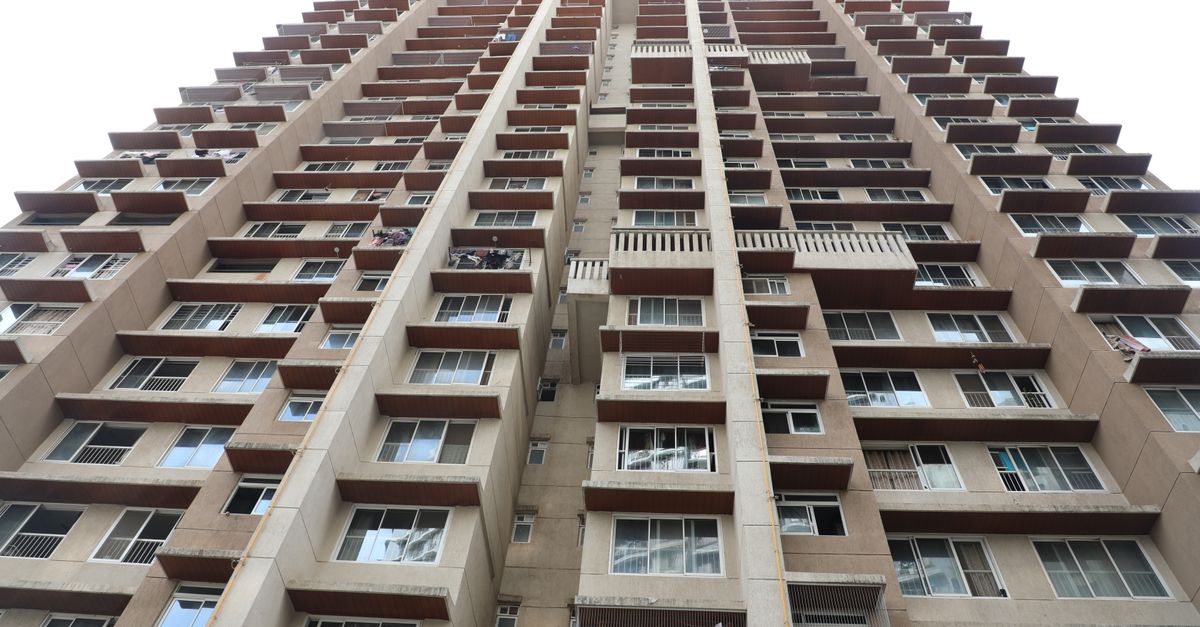 Upward perspective of a high-rise apartment building showcasing modern urban architecture.