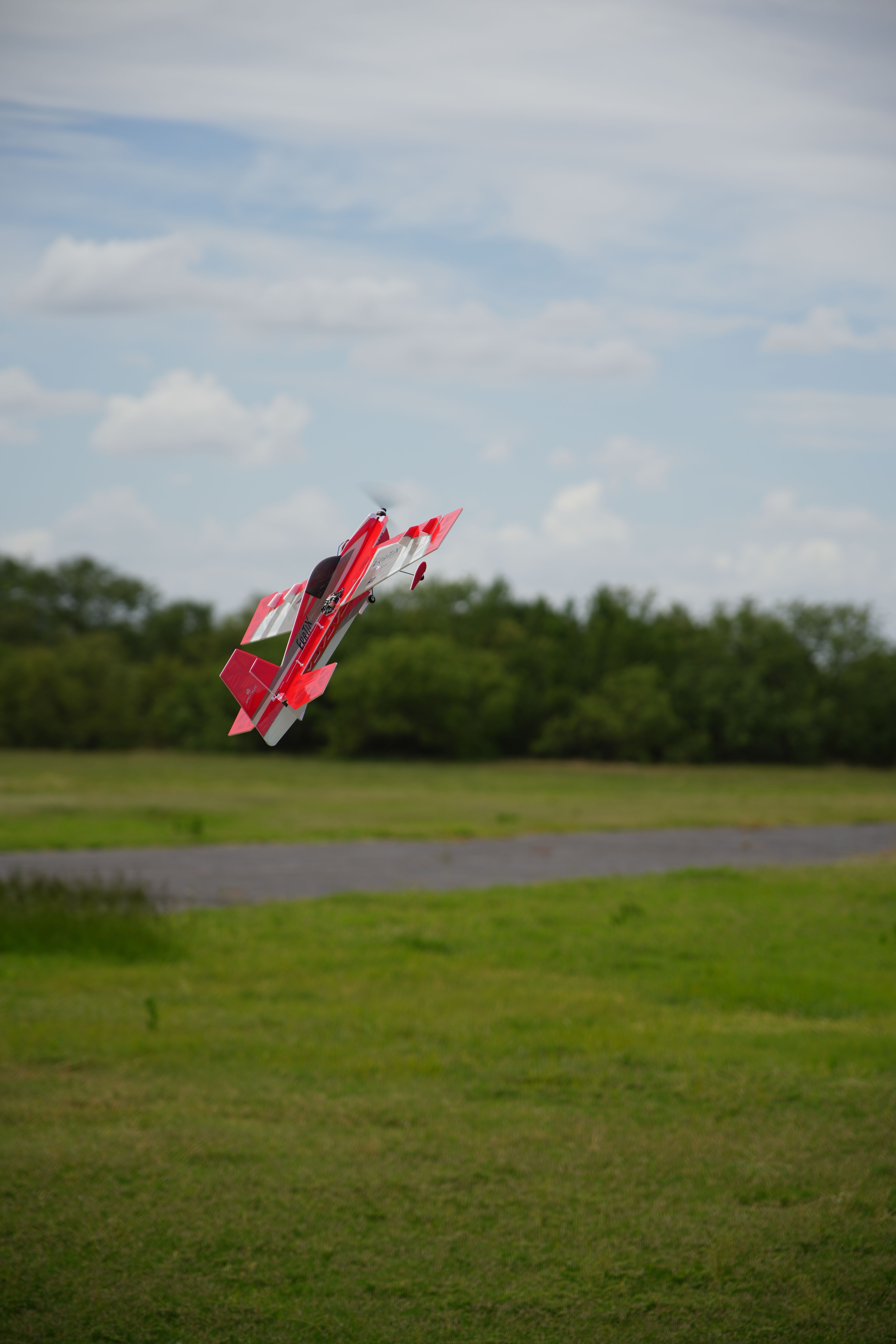 Remote control plane soaring mid-flight over a scenic field in Wichita Falls, Texas.