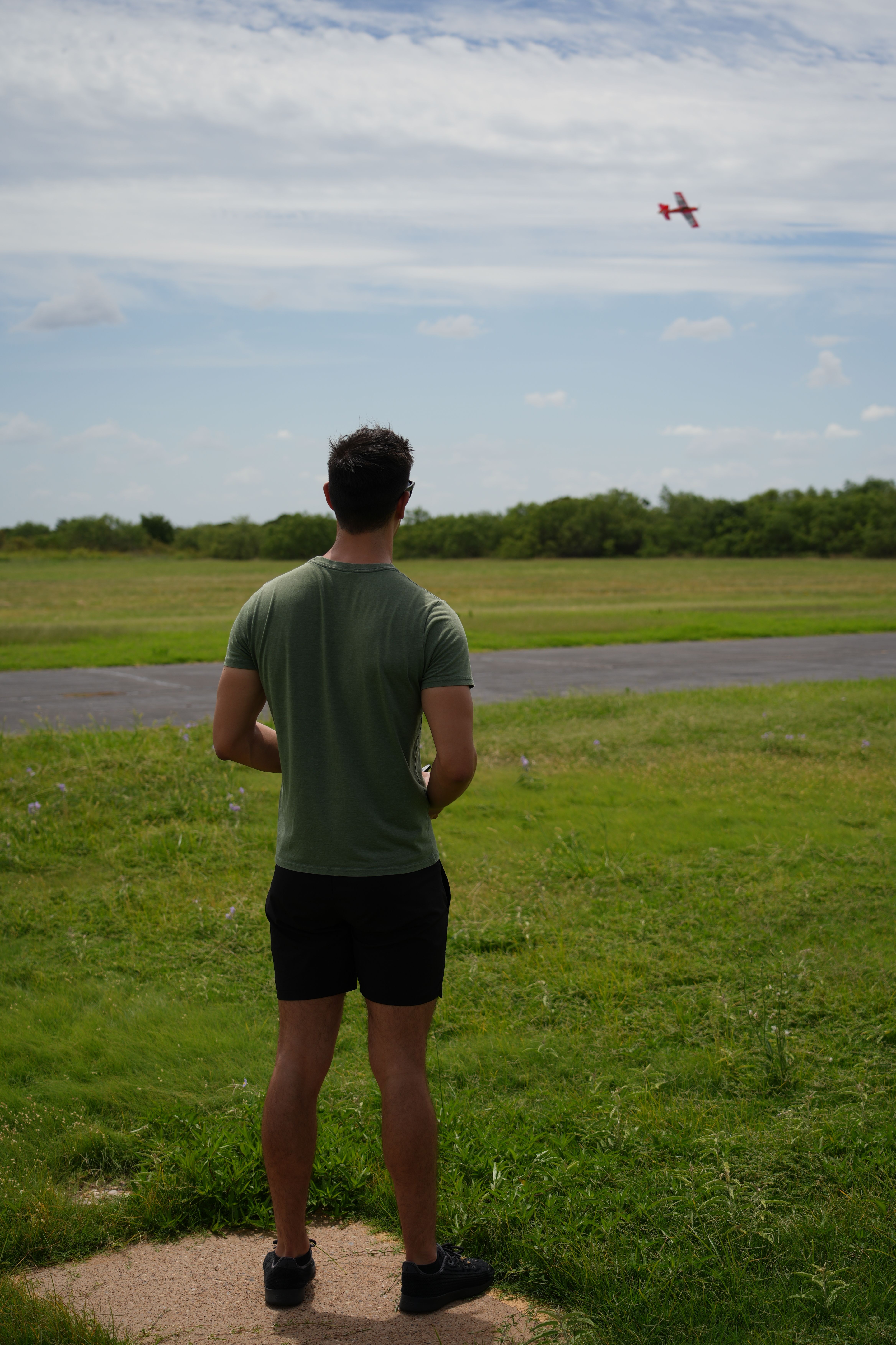 A man operates a remote-controlled plane on a grassy field in Wichita Falls, Texas.