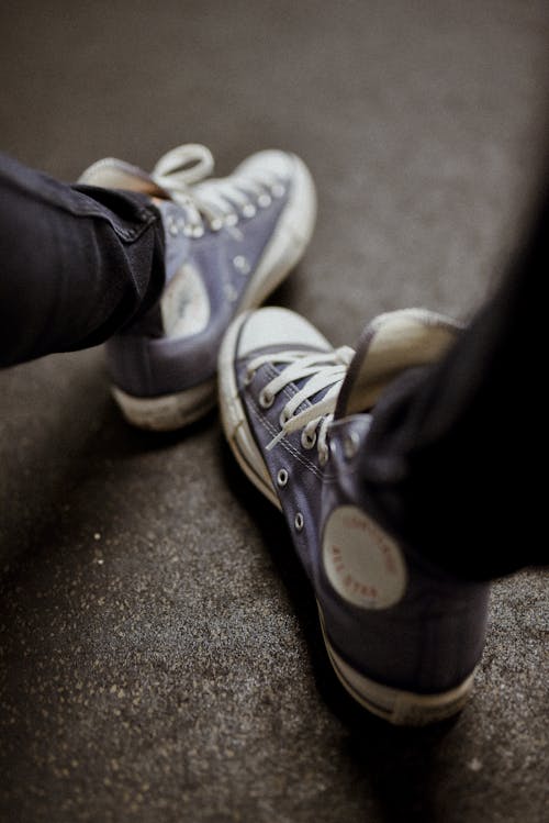 Persona Che Indossa Jeans Blu Denim E Scarpe Da Ginnastica Alte Bianche Converse All Star