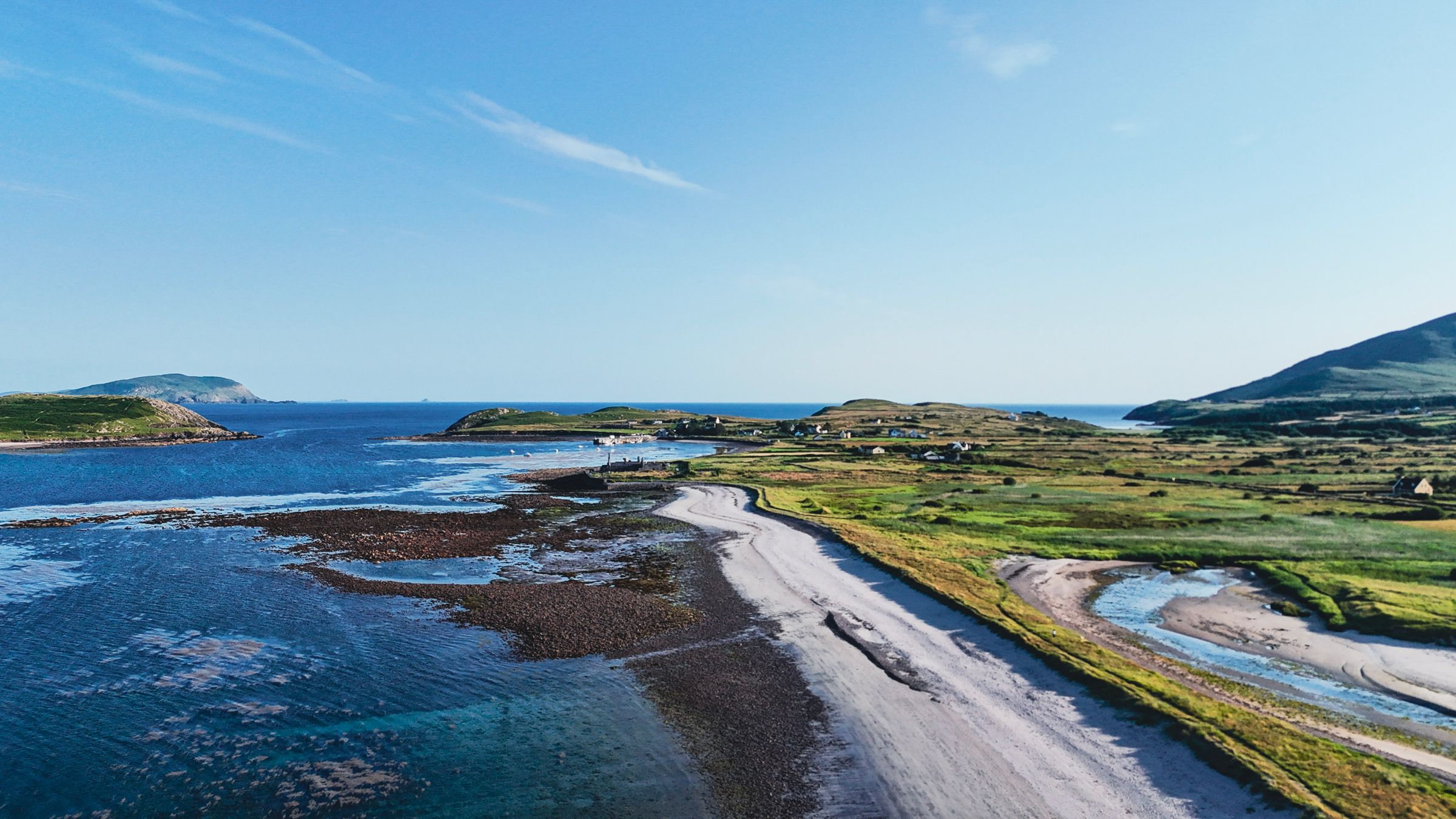 Aerial photograph of the coastline in County Kerry, Ireland, capturing clear blue waters and green landscapes