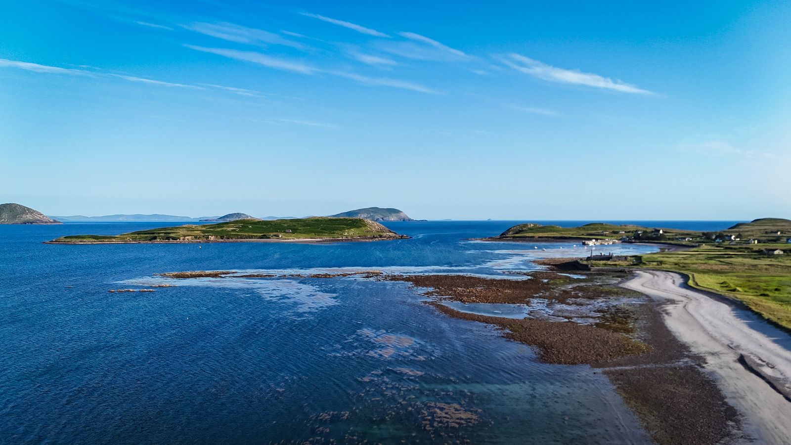 Aerial view of a coastal landscape in County Kerry, Ireland, showcasing blue waters and green islands