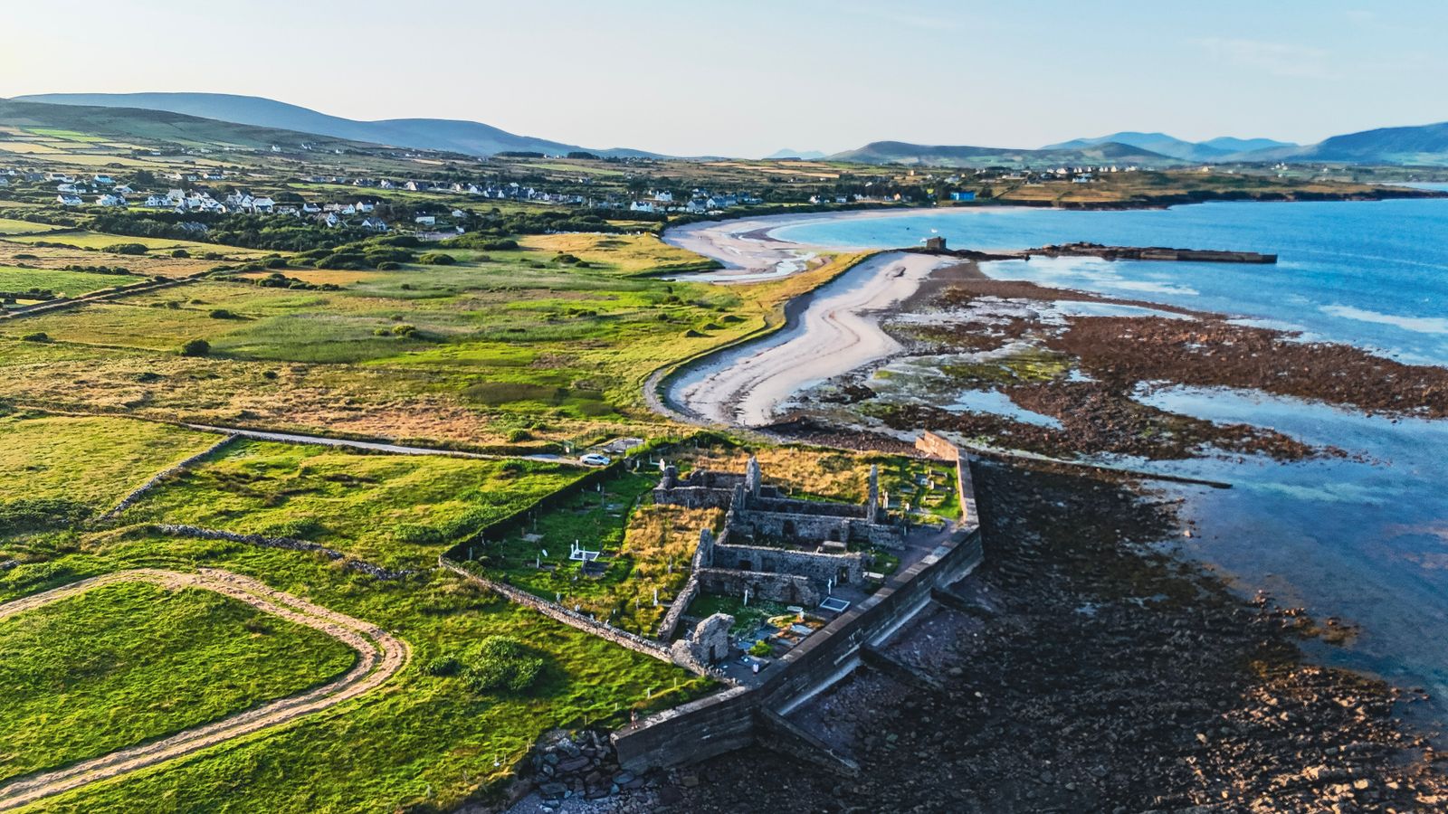 Aerial shot of County Kerry's coastline with historic ruins and sea view
