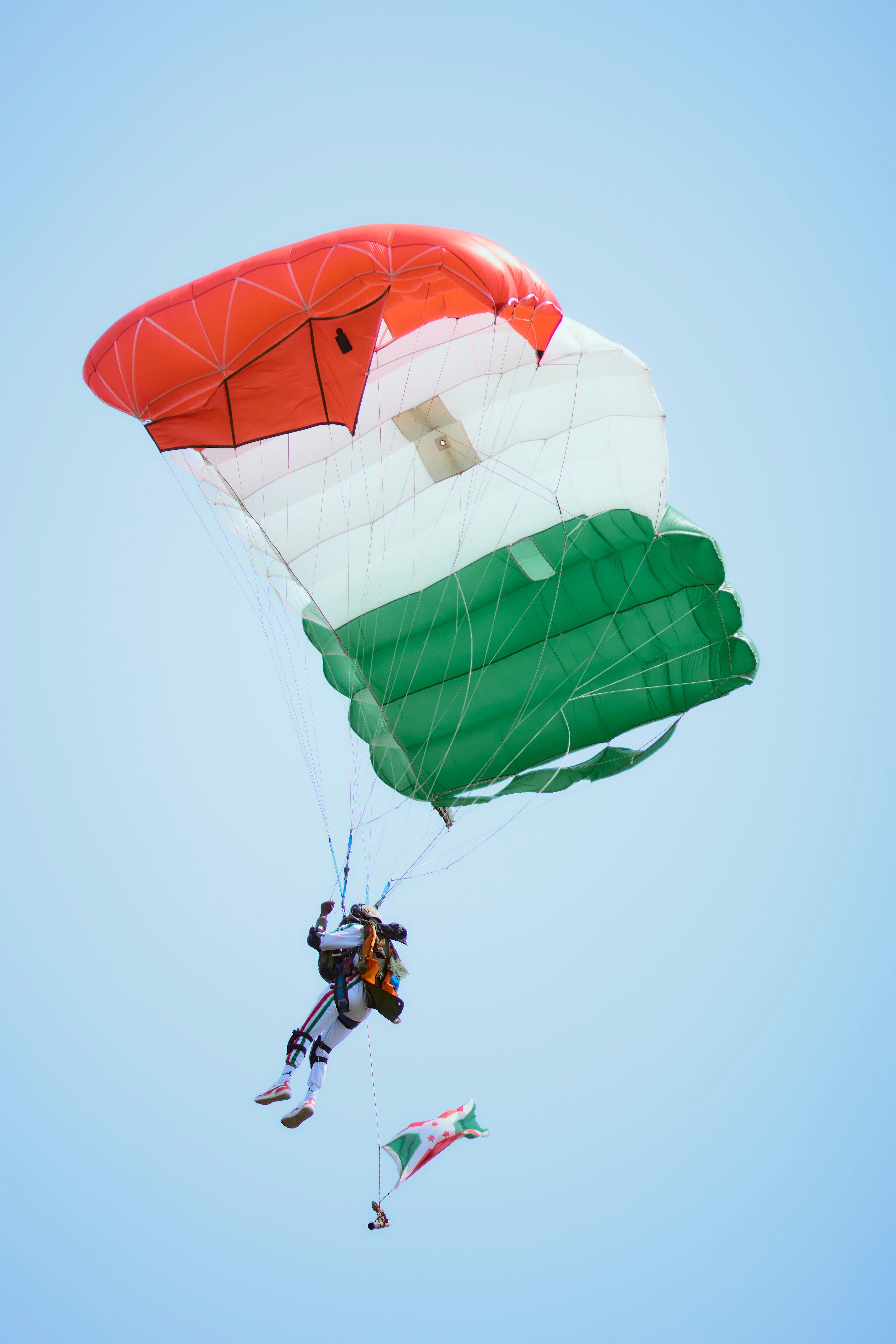 Paraglider with multicolored parachute mid flight, Niger