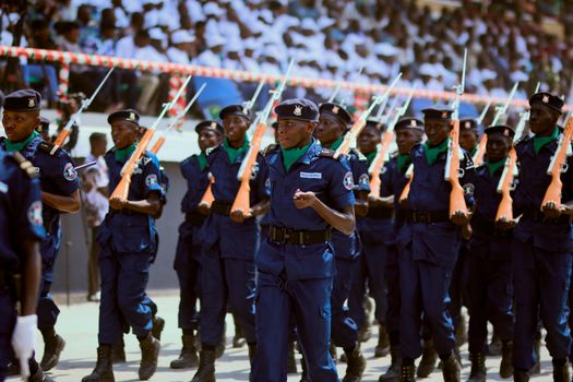 A disciplined display of police officers marching with rifles during a ceremonial parade.