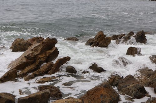 Free Dynamic ocean waves crashing over rugged rocky coastline, creating a dramatic seascape. Stock Photo