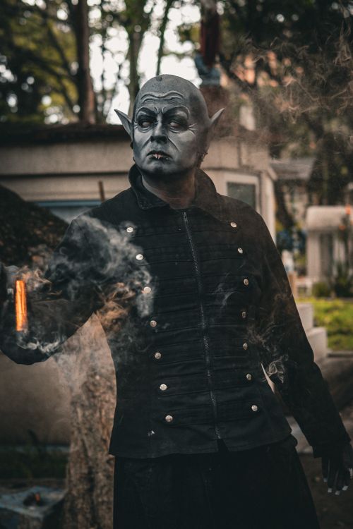 Free Mystical character in makeup amid smoke and outdoor setting, creating an eerie atmosphere. Stock Photo