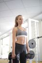 Strong slender female with dumbbells