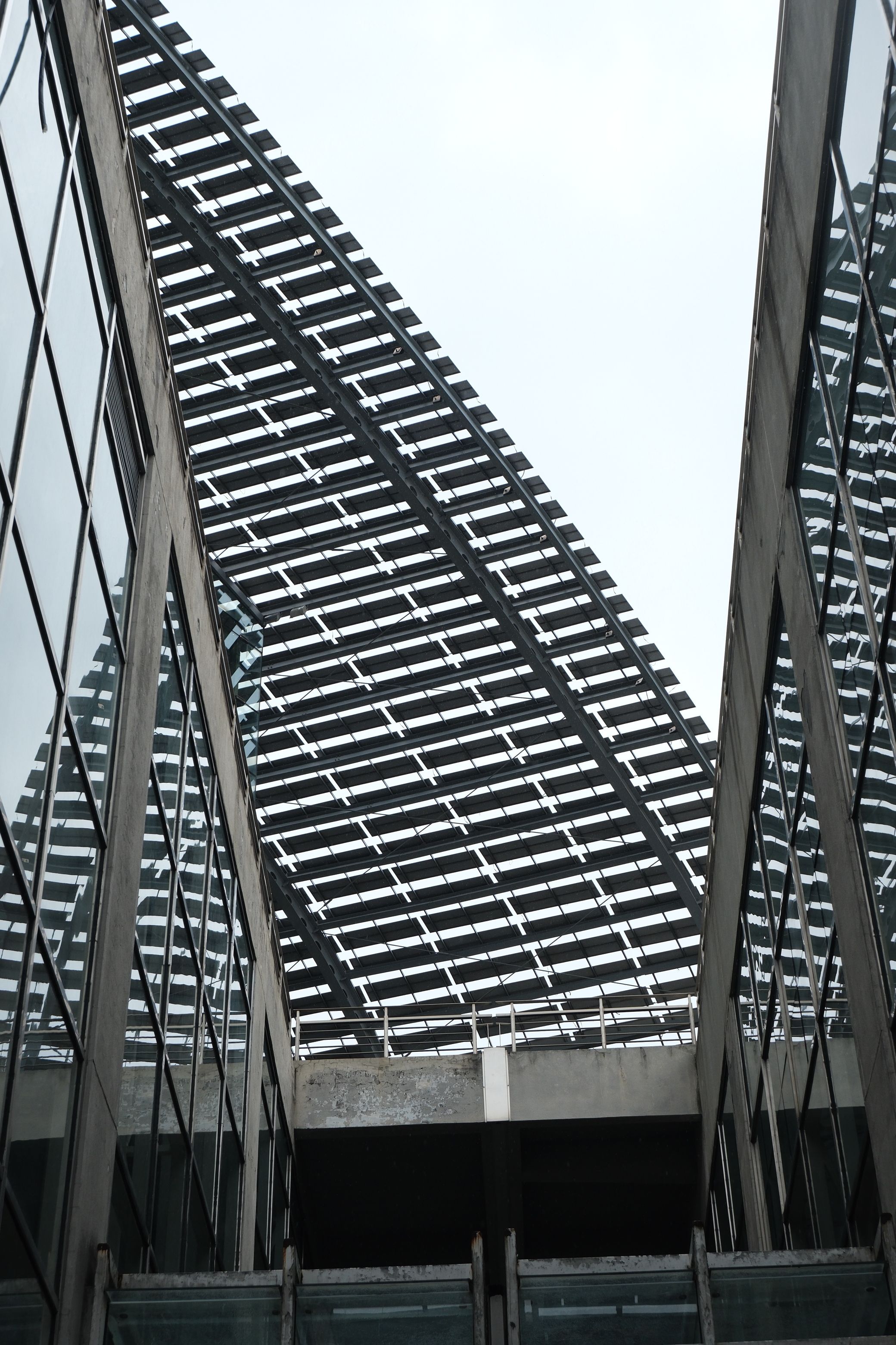 A contemporary building showcasing a triangular geometric roof structure with reflective glass surfaces.