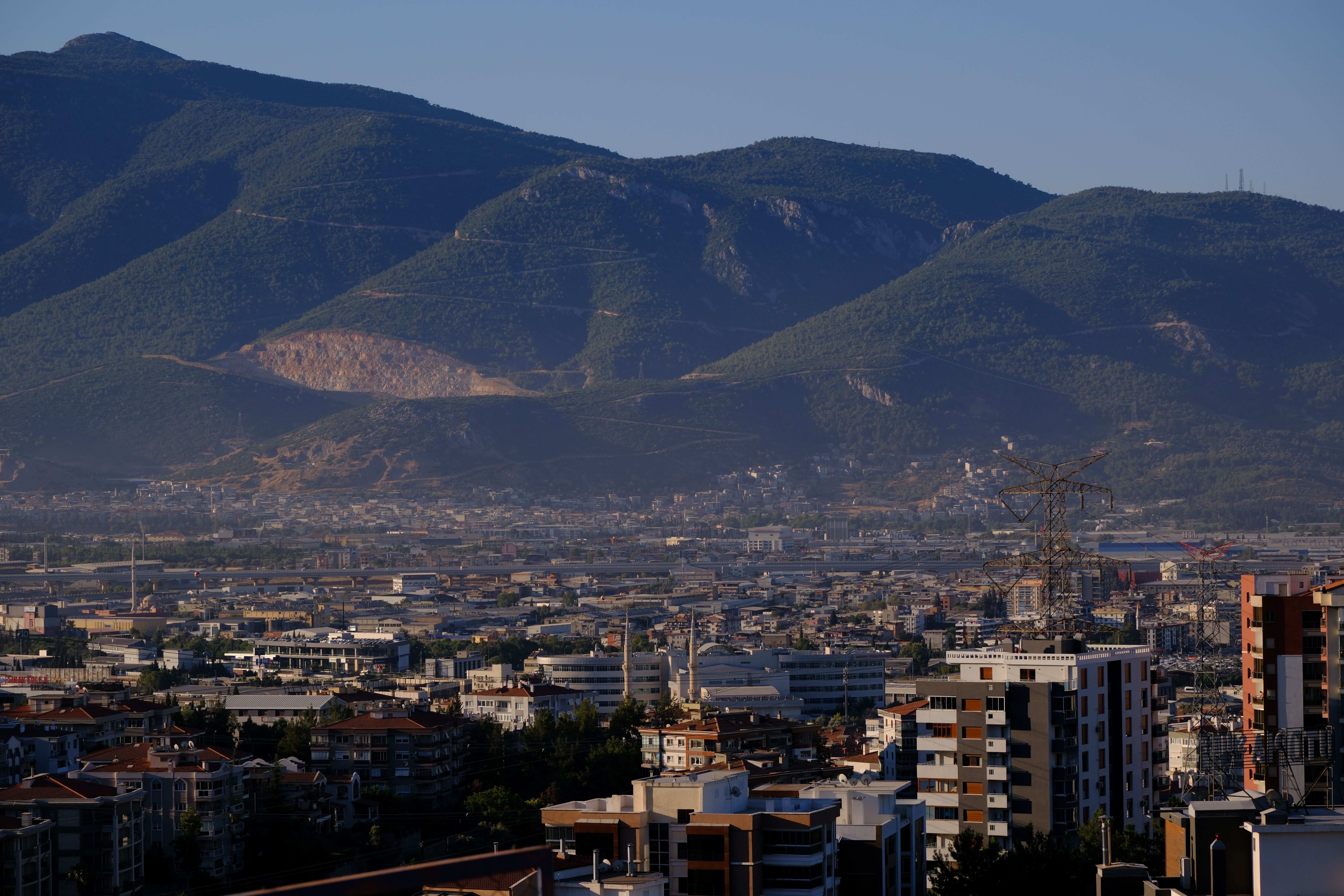 A stunning view of İzmir cityscape against a mountainous backdrop captured in daylight.