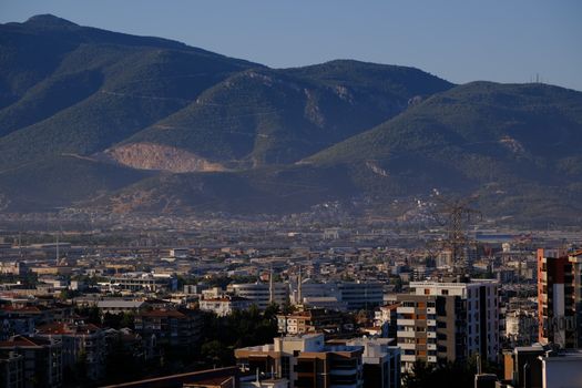 A stunning view of İzmir cityscape against a mountainous backdrop captured in daylight.