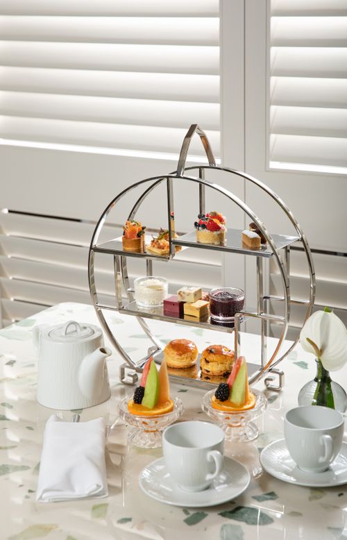 Free Luxurious afternoon tea setup featuring pastries, scones, and tea cups, ideal for elegant dining experiences. Stock Photo