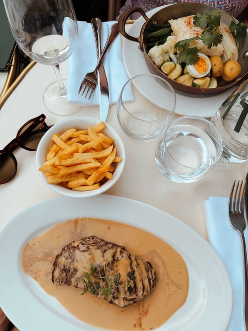 Free A sophisticated dining table set with gourmet dishes including steak and fries, perfect for a chic dining experience. Stock Photo