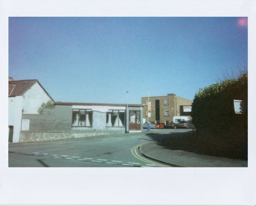 Free A quiet street corner with vintage buildings under a clear blue sky. Stock Photo